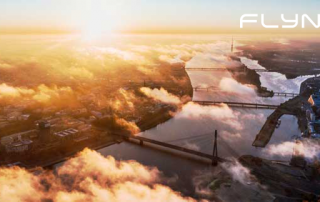 Drohnenbild über Fluss mit Brücke mit Wolken