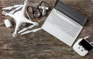 drone, camera and laptop on an old board