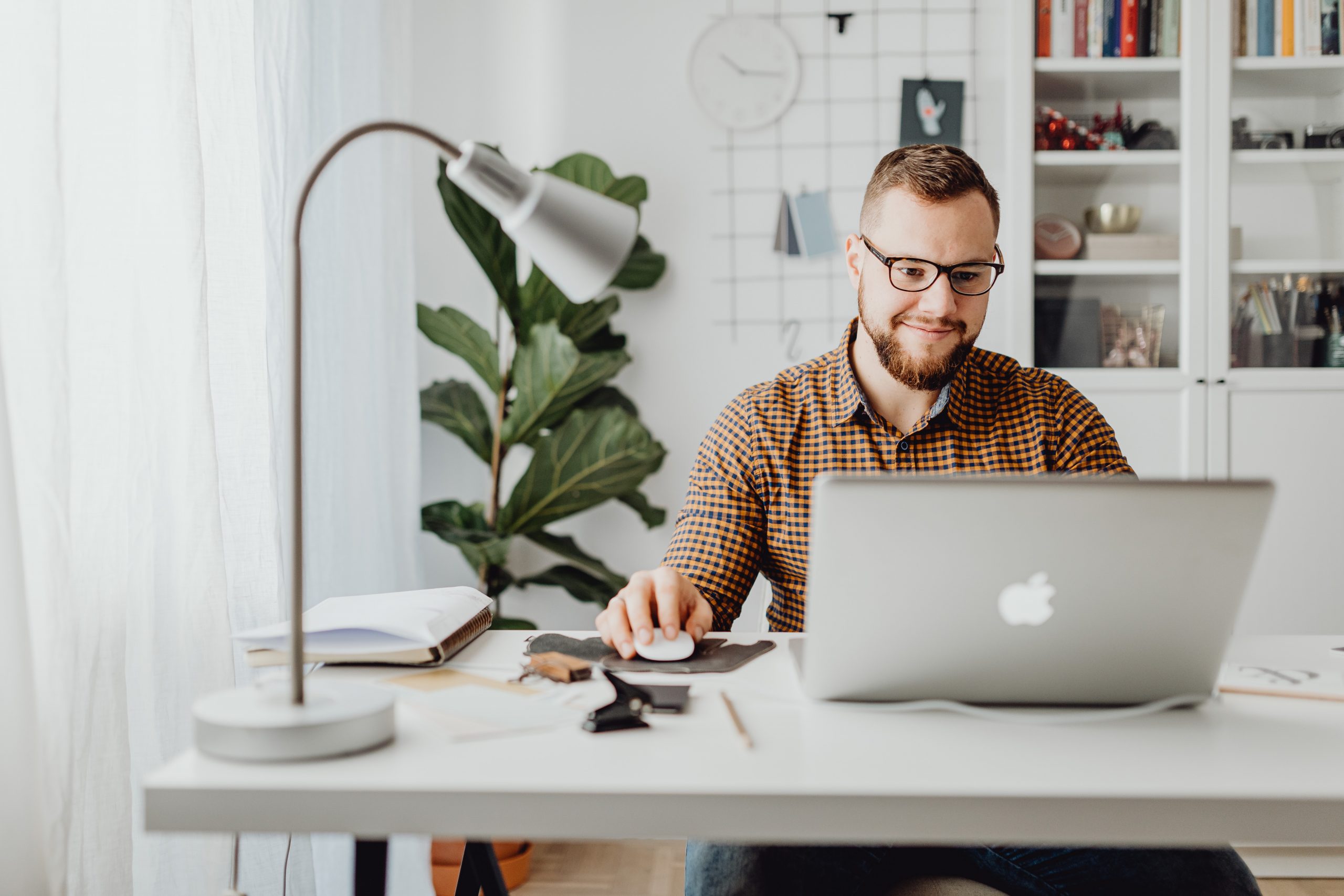 A man sitting at a desk in front of a laptop