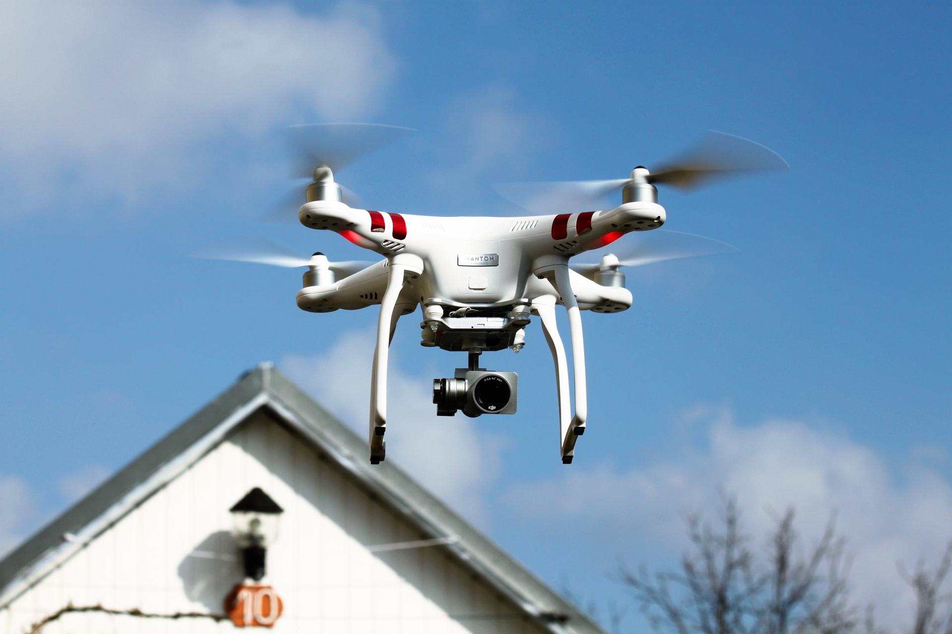 Fliegende Drohne vor einem Haus